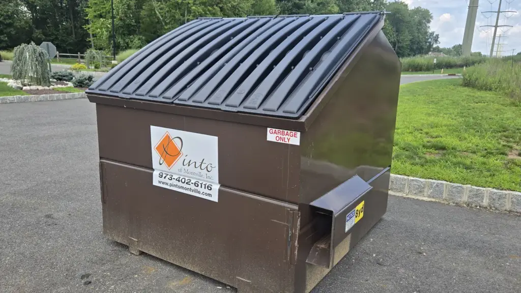 A brown Pinto of Montville front-load commercial container with the company decal